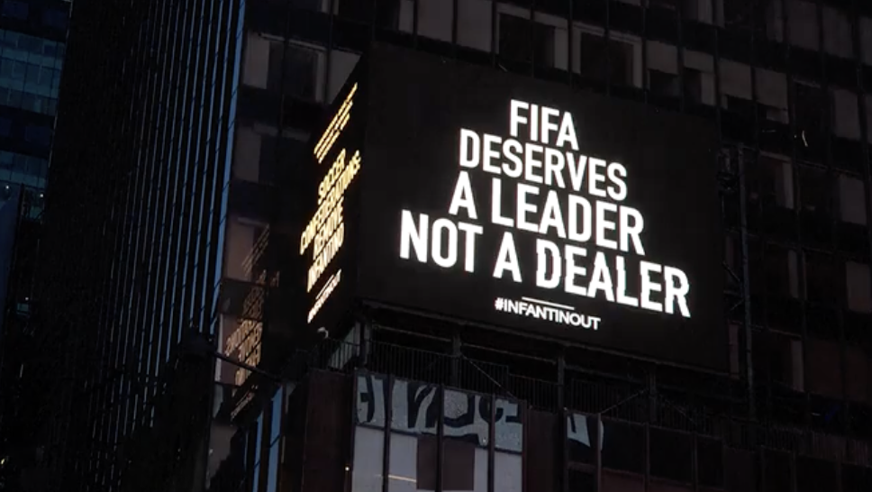 Times Square billboard screams for Infantino to go; FIFA boss ducks questions in Poland